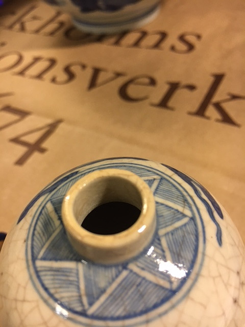 A SMALL BLUE AND WHITE BOTTLE.