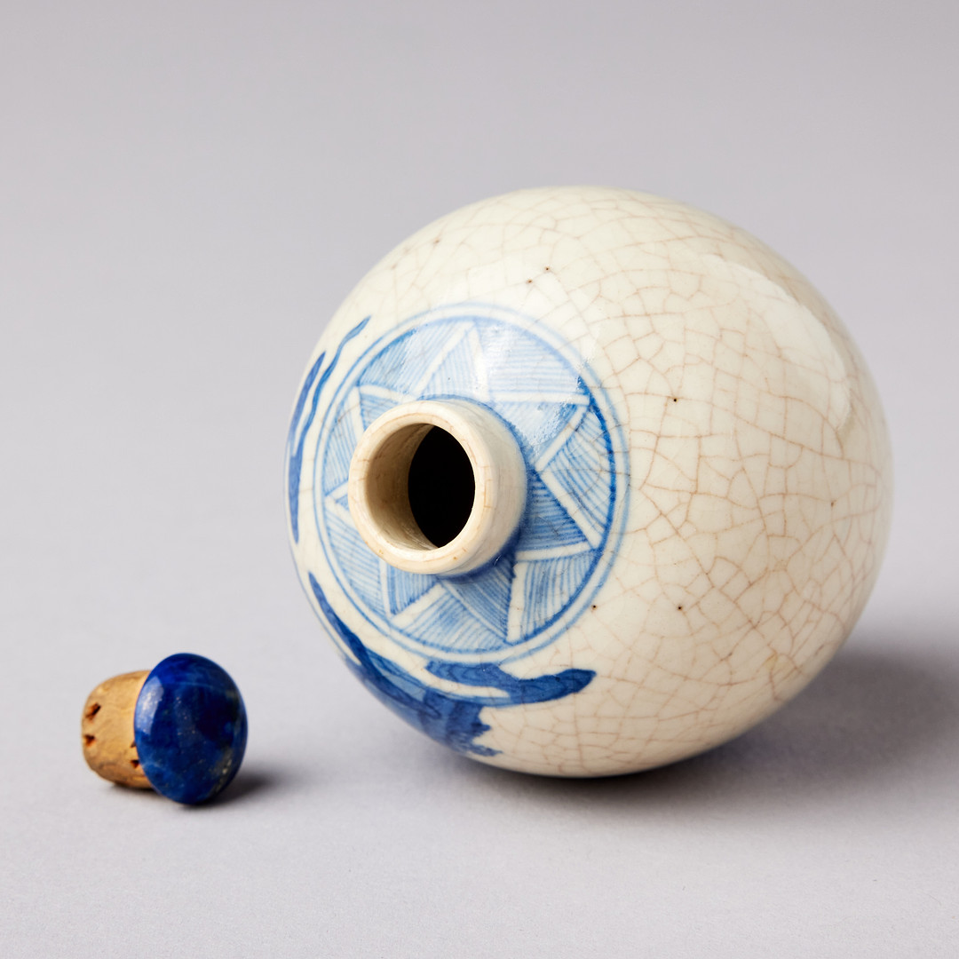 A SMALL BLUE AND WHITE BOTTLE.
