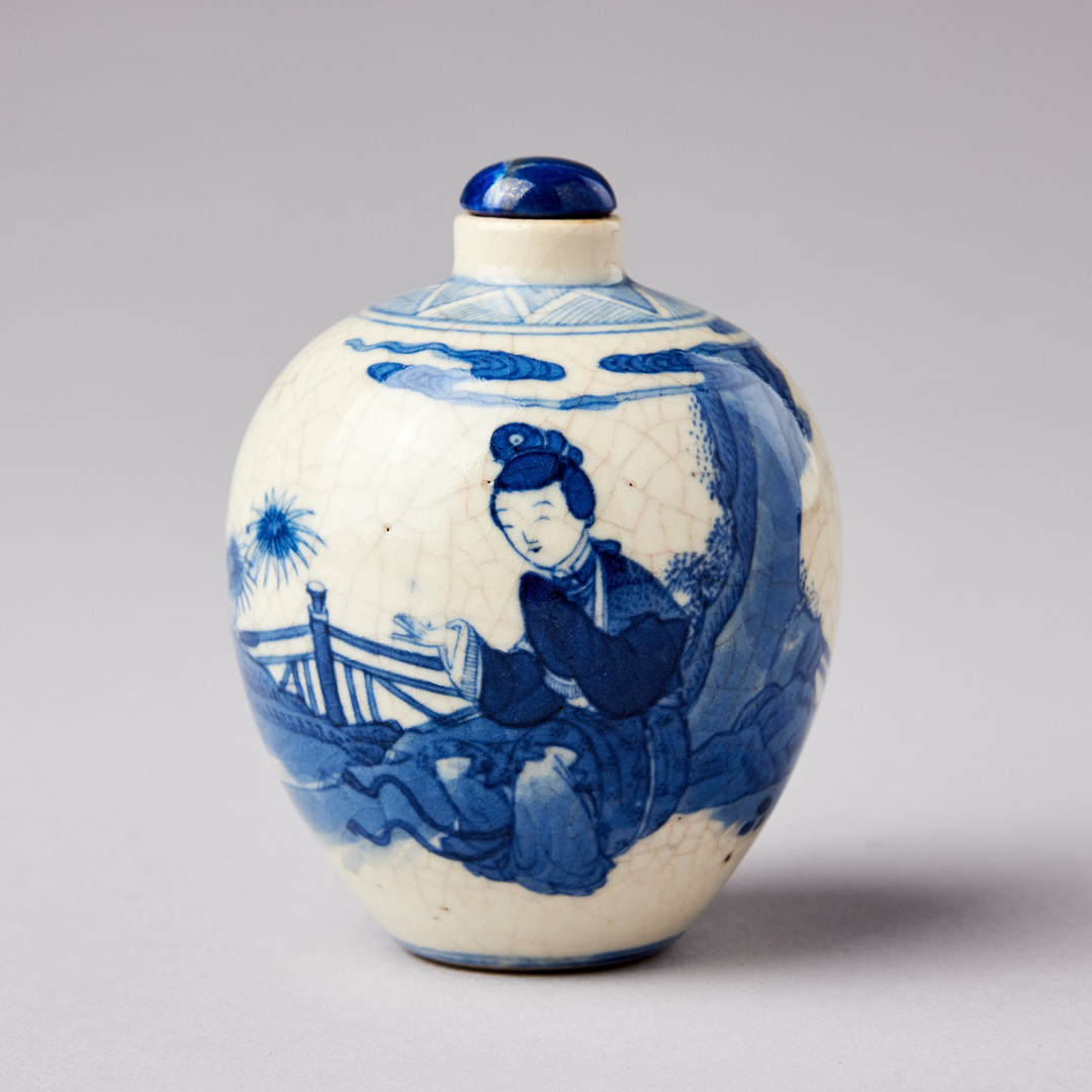 A SMALL BLUE AND WHITE BOTTLE.