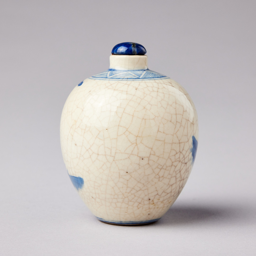 A SMALL BLUE AND WHITE BOTTLE.