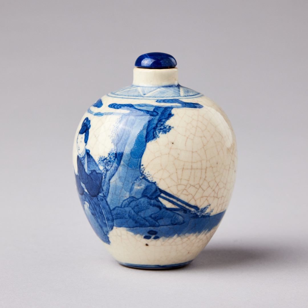 A SMALL BLUE AND WHITE BOTTLE.