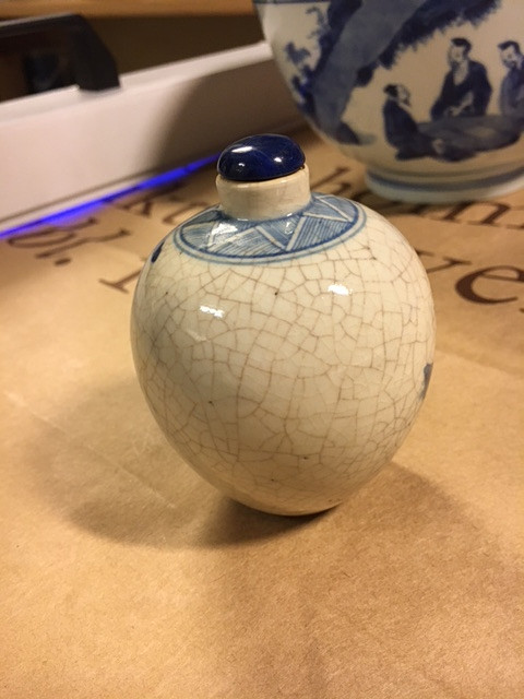 A SMALL BLUE AND WHITE BOTTLE.
