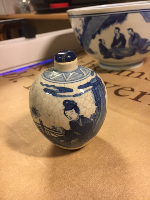 A SMALL BLUE AND WHITE BOTTLE.