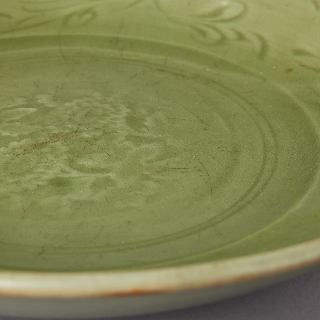 A CELADON CARVED AND IMPRESSED DISH.