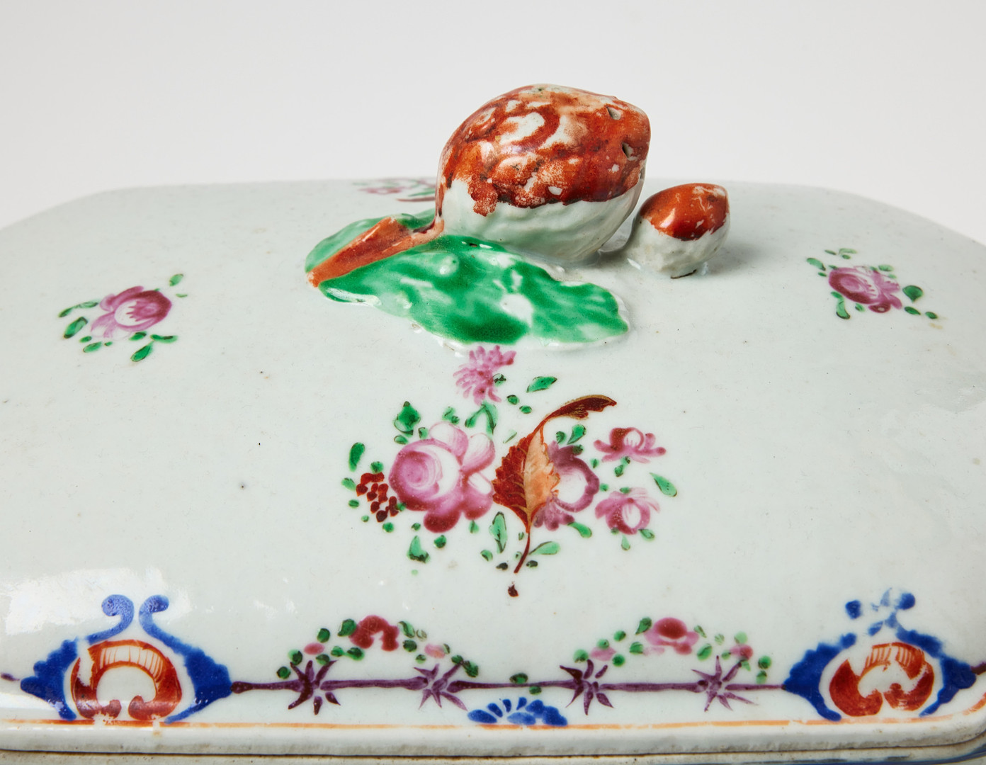 TERRIN MED UNDERFAT, porslin, Kina, Qianlong (1736-1795), europeiserande dekor av strödda blommor, hänklar i form av svinhuvuden, fatet med konturerat brätte och girland i emaljfärger.