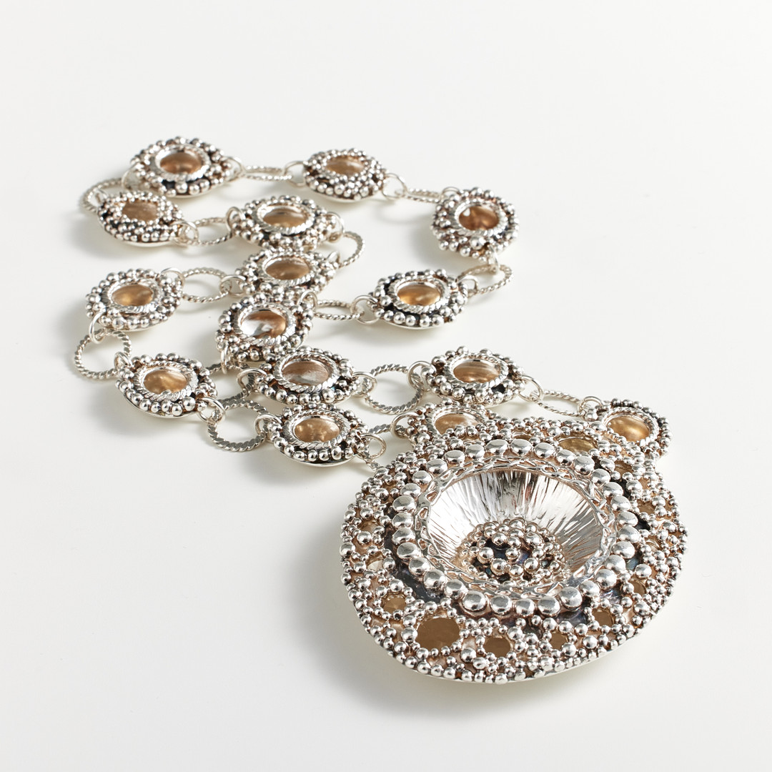 ROSA TAIKON OCH BERND JANUSCH, collier, sterlingsilver, Trollbäcken 1971, genombrutet skålformat hänge med intrikat dekor av granulater, halskedja med tvinnad tråd samt skålformade mellandelar.