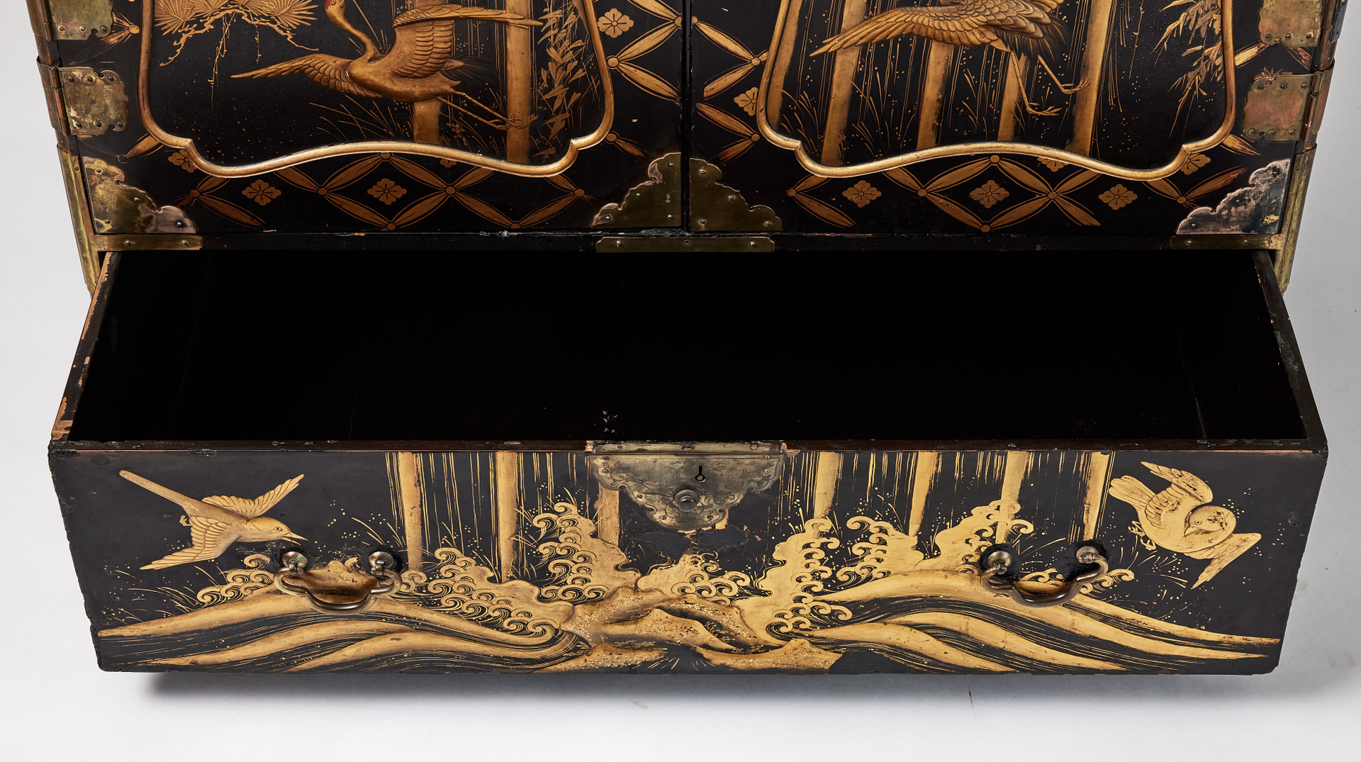 A RARE GOLD AND BLACK LACQUER 'TANSU' CABINET.