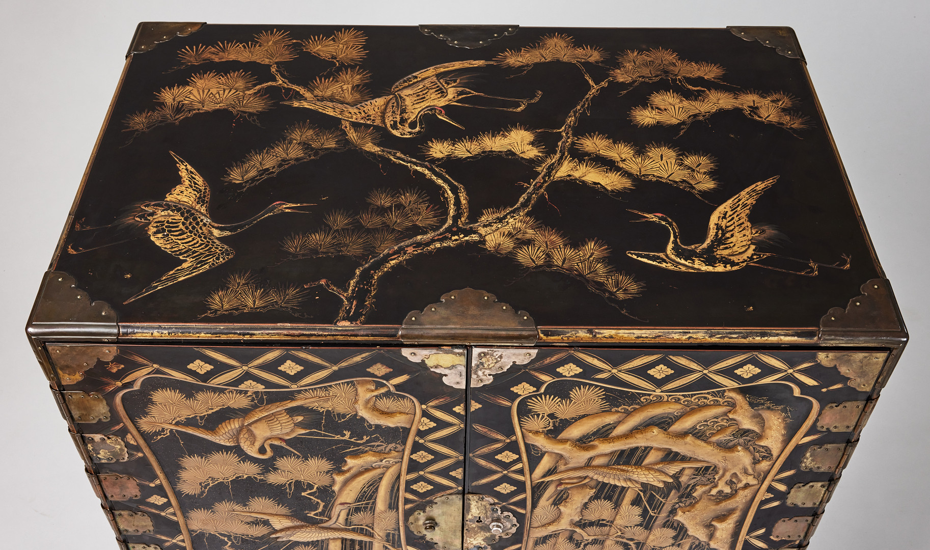 A RARE GOLD AND BLACK LACQUER 'TANSU' CABINET.