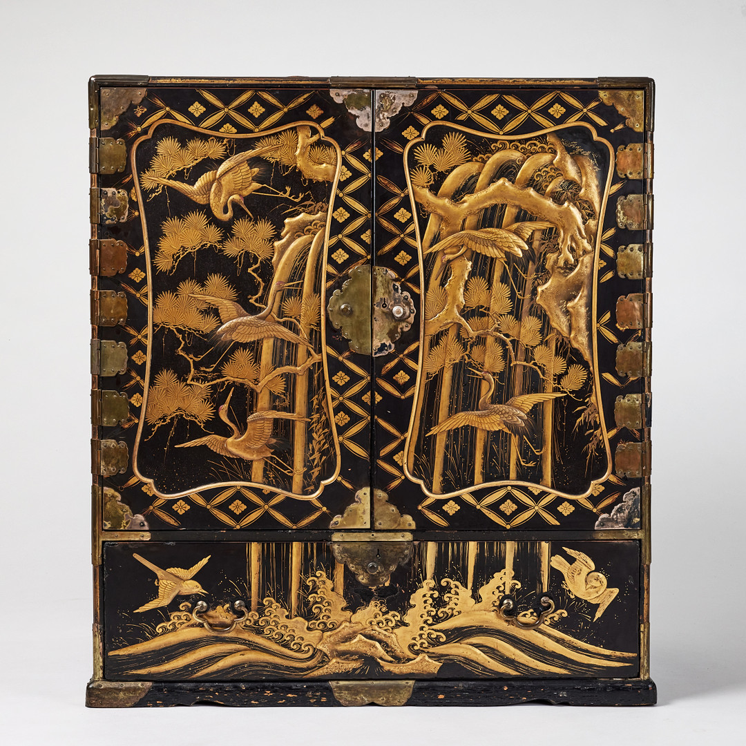 A RARE GOLD AND BLACK LACQUER 'TANSU' CABINET.