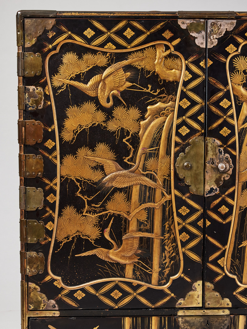 A RARE GOLD AND BLACK LACQUER 'TANSU' CABINET.