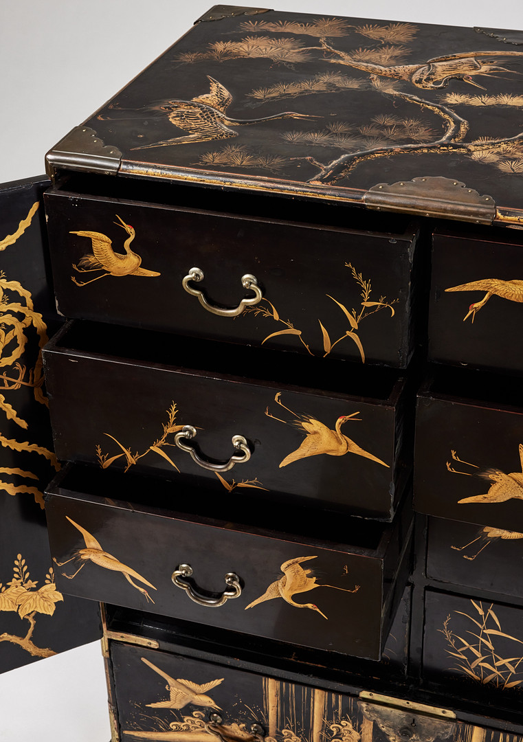 A RARE GOLD AND BLACK LACQUER 'TANSU' CABINET.