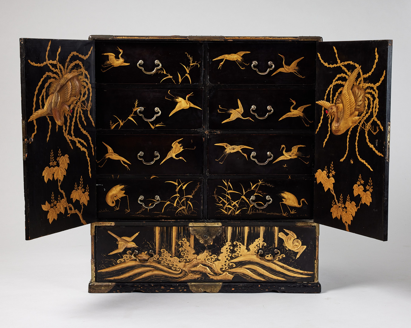 A RARE GOLD AND BLACK LACQUER 'TANSU' CABINET.