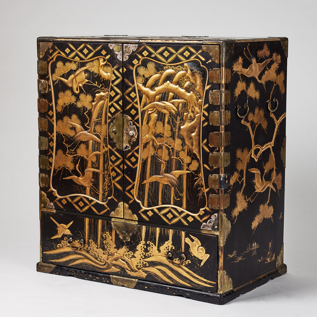 A RARE GOLD AND BLACK LACQUER 'TANSU' CABINET.