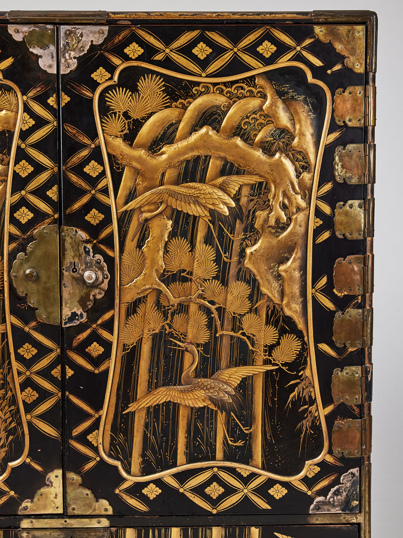 A RARE GOLD AND BLACK LACQUER 'TANSU' CABINET.
