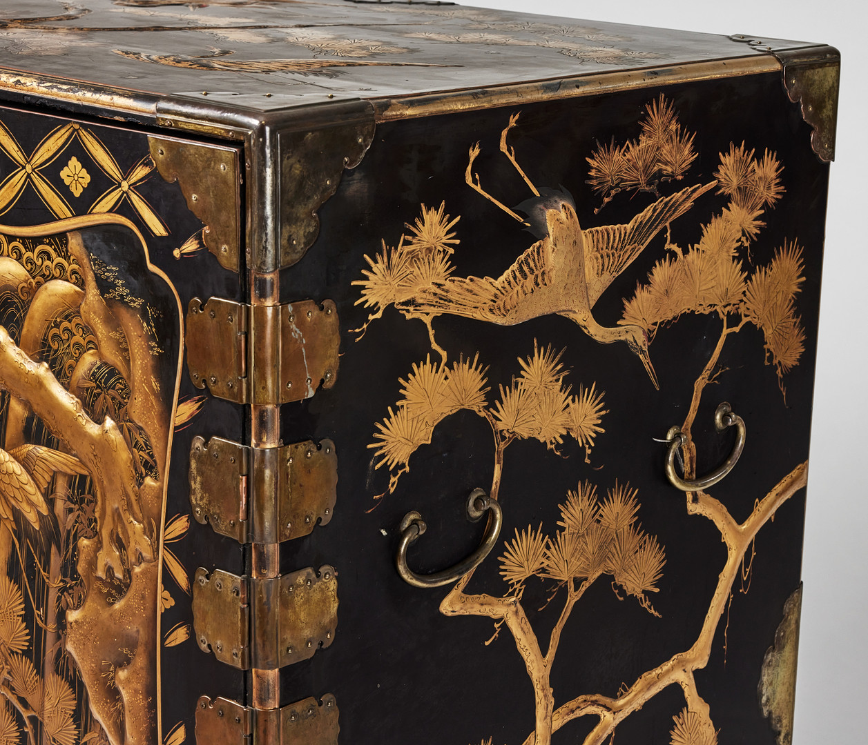 A RARE GOLD AND BLACK LACQUER 'TANSU' CABINET.
