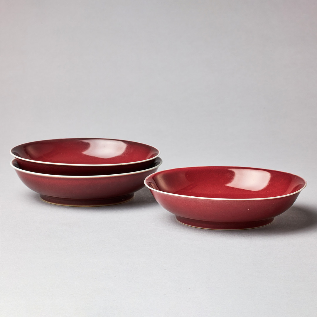 A SET OF THREE SANG-DE-BOEUF SAUCER DISHES.