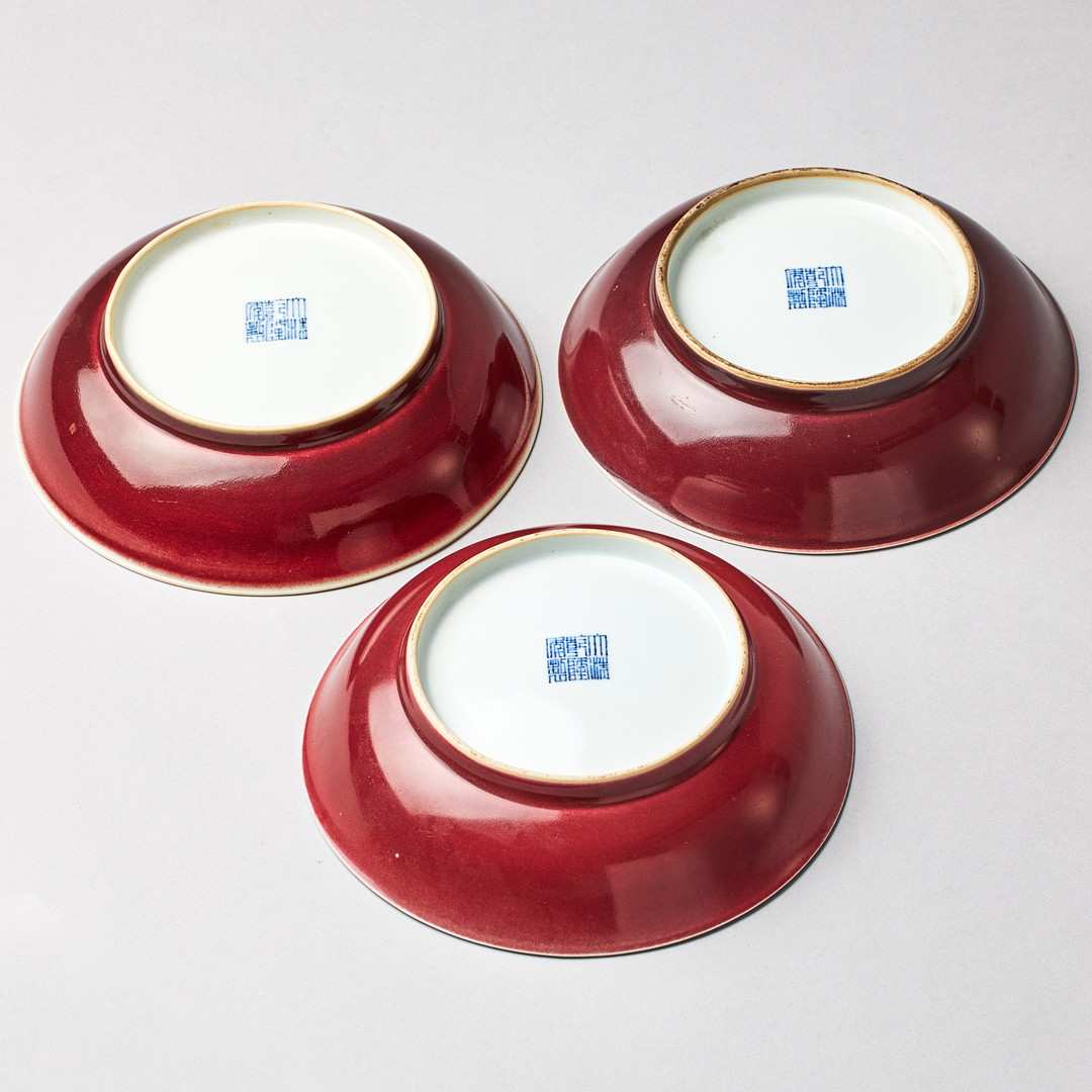A SET OF THREE SANG-DE-BOEUF SAUCER DISHES.