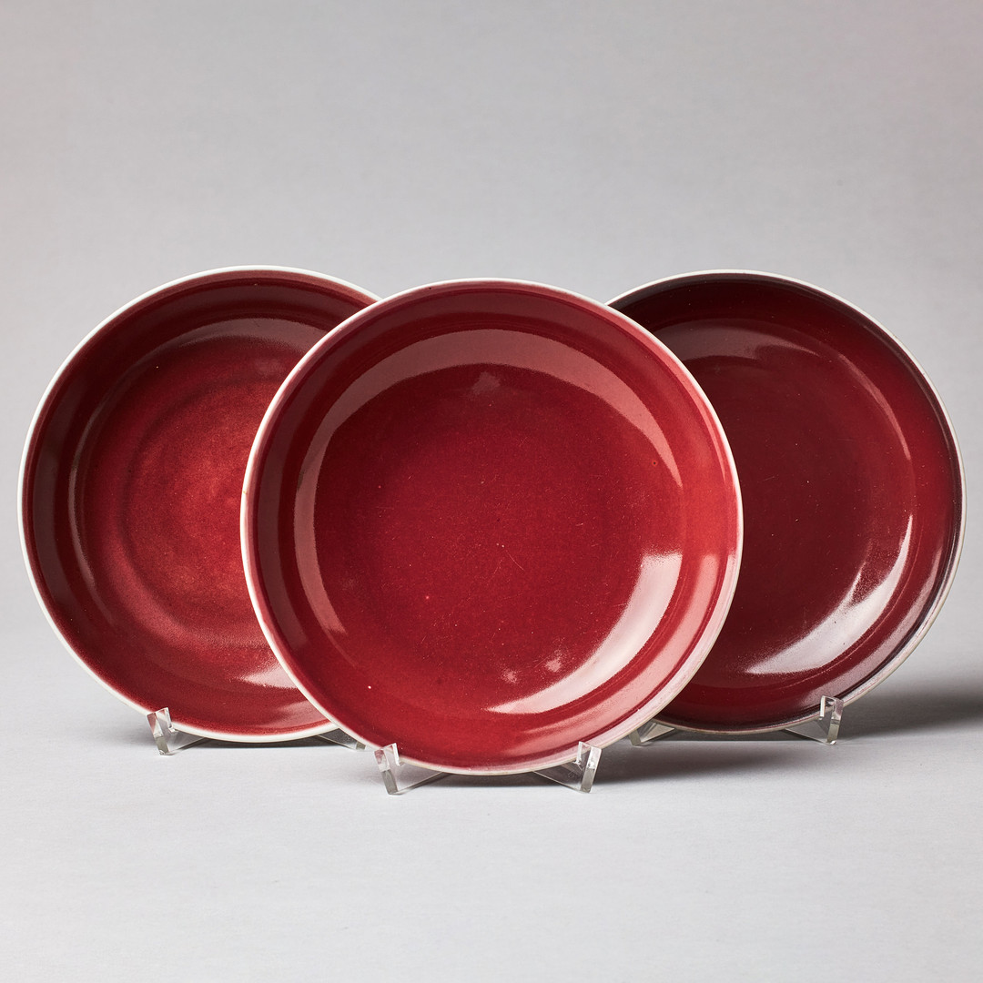 A SET OF THREE SANG-DE-BOEUF SAUCER DISHES.