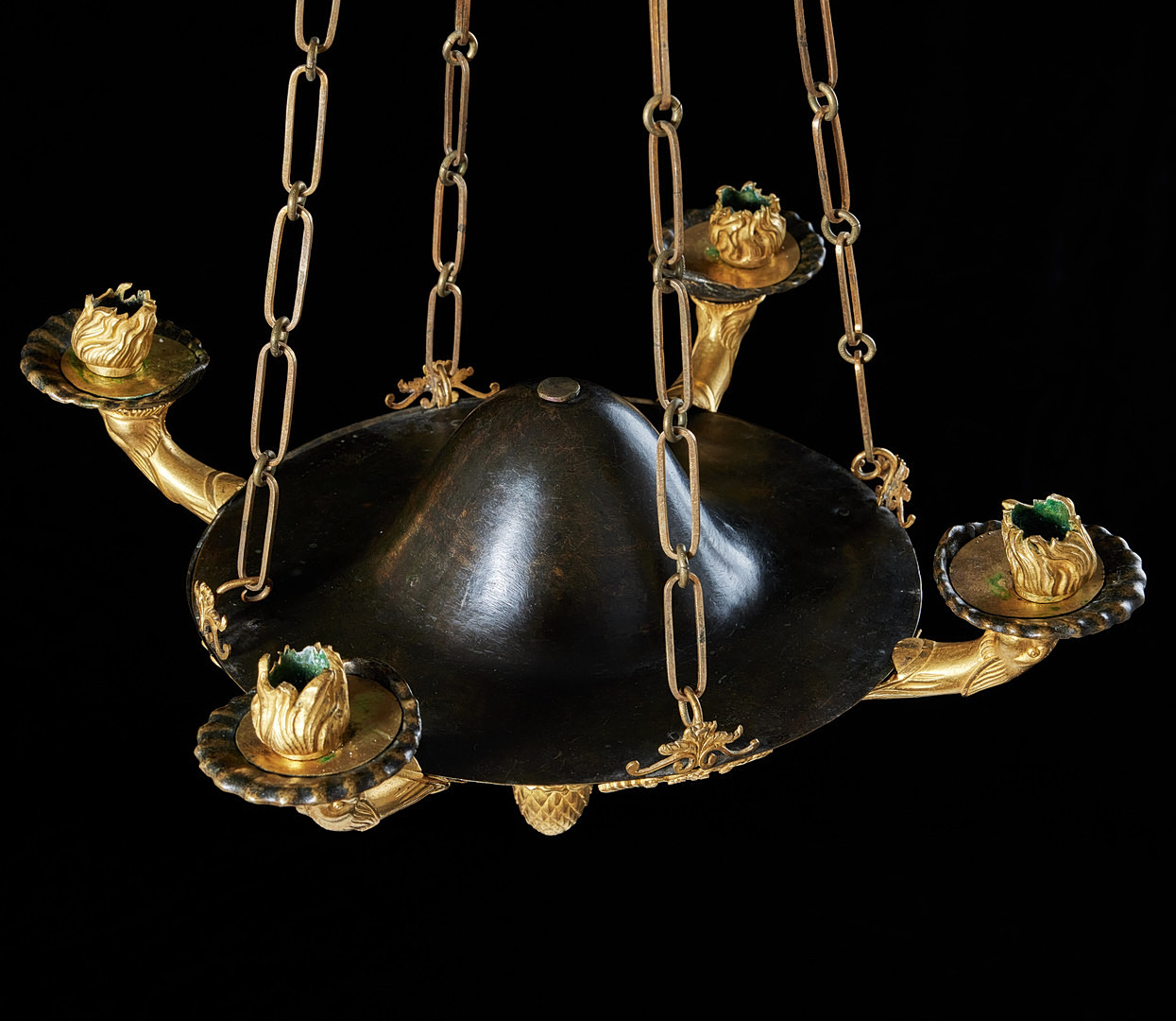 AMPEL, stockholmsarbete i empire, 1800-talets första kvartal, för fyra ljus, i form av romersk oljelampa, matterad och polerad brännförgylld brons samt förgylld och mörkpatinerad mässing.