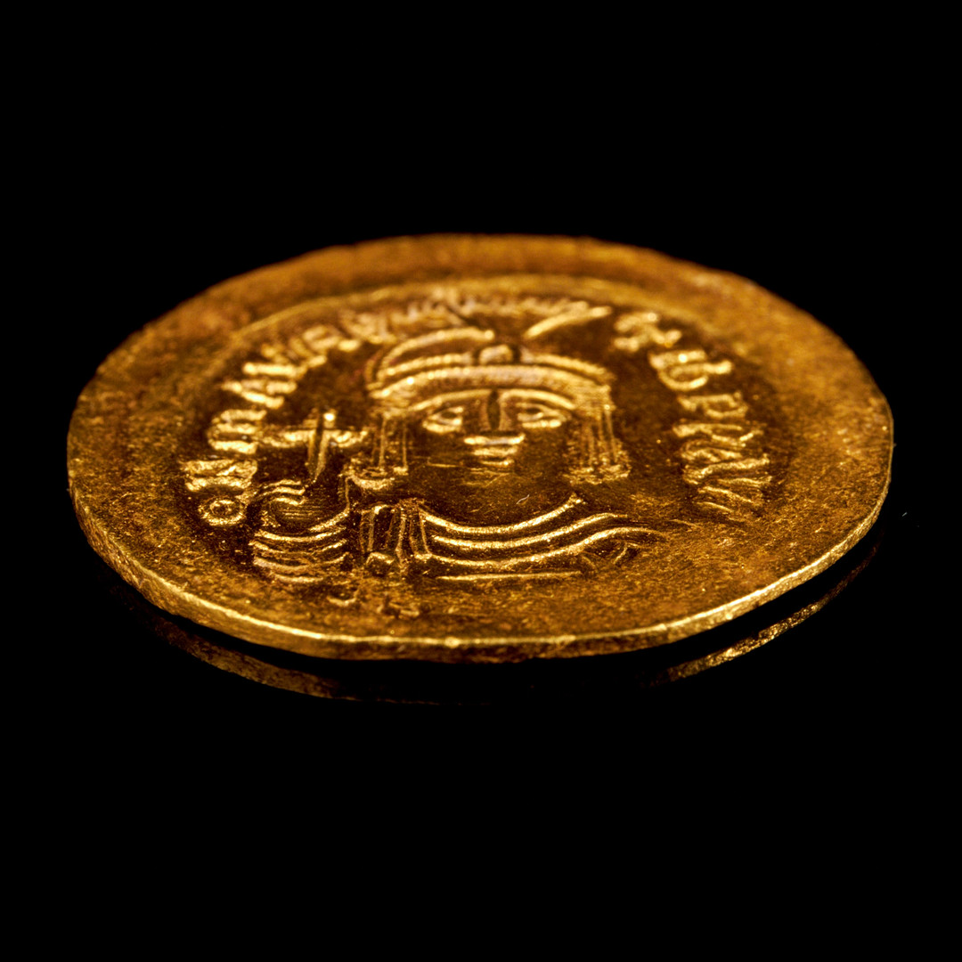 GULDMYNT, Maurikios Tiberios, bysantinsk kejsare 582-602, solidus, präglad i Konstantinopel, åtsidan med kejsaren avbildad hållande ett riksäpple, frånsidan med segergudinnan Victoria med en staurogramstav samt ett riksäpple.