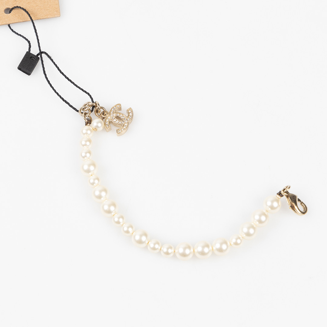 CHANEL, Armband, Costume jewelry, Faux Pearl och guldpläterat CC-berlock med strasstenar, 2011.
