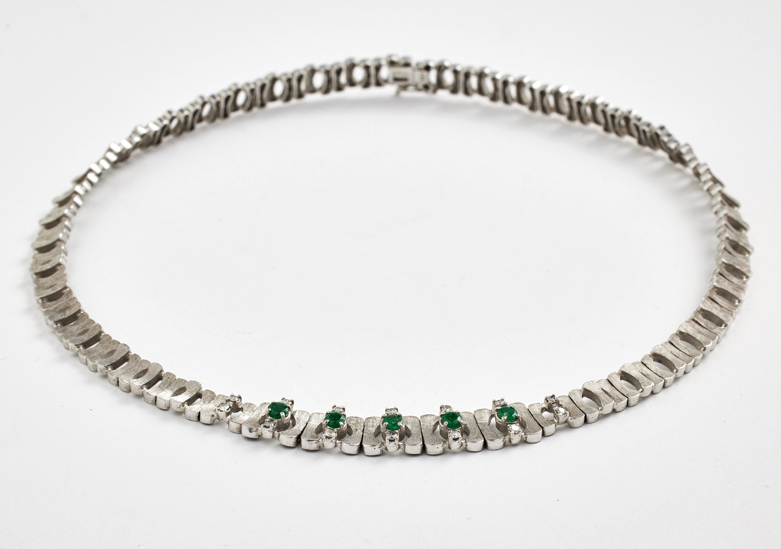 COLLIER, 18 k satinerat vitguld, halvstel länk, mittparti med dekor av 5 fasettslipade smaragder samt 14 briljanter totalt ca 0,35 ct.