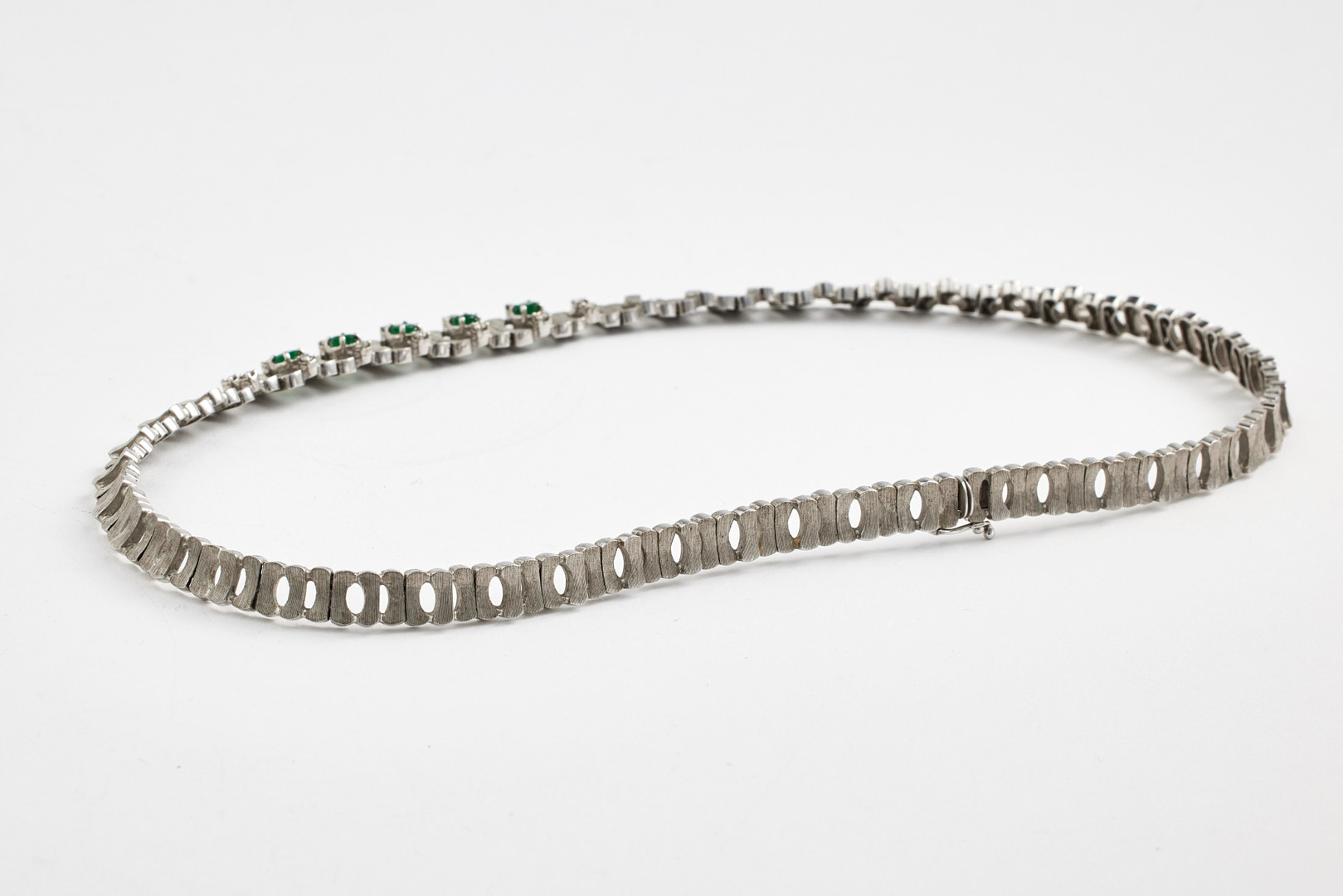 COLLIER, 18 k satinerat vitguld, halvstel länk, mittparti med dekor av 5 fasettslipade smaragder samt 14 briljanter totalt ca 0,35 ct.