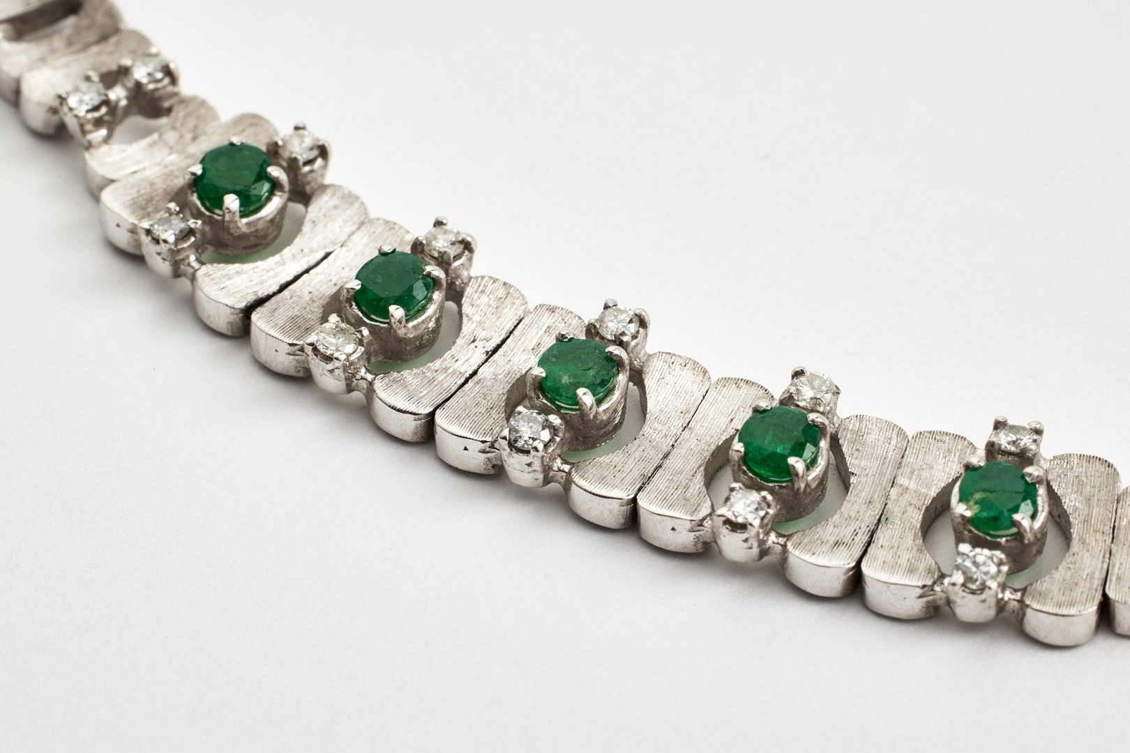 COLLIER, 18 k satinerat vitguld, halvstel länk, mittparti med dekor av 5 fasettslipade smaragder samt 14 briljanter totalt ca 0,35 ct.