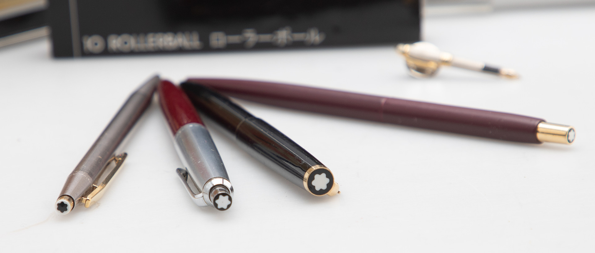 MONTBLANC. Kleine Montblanc-Sammlung: 3 Kugelschreiber, 1 Bleistift, 1 Button und 1 Etui mit Rollerball-Minen, 1 Blechdose und ein Buch (8).