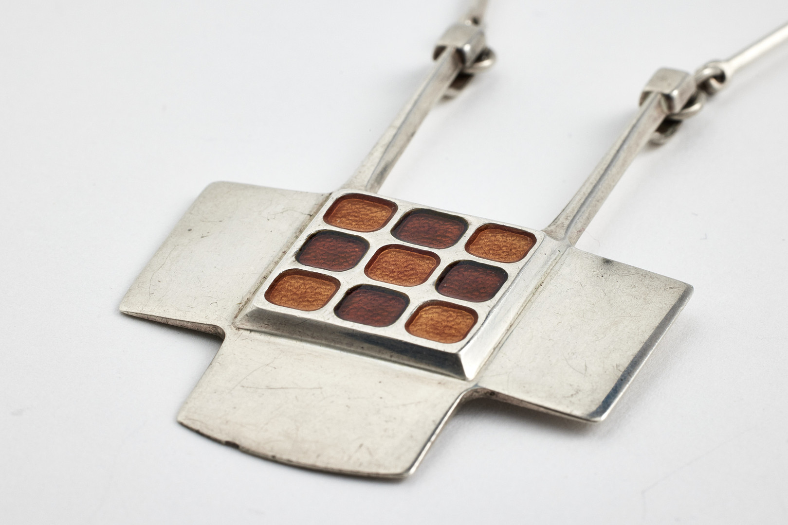 DAVID ANDERSEN. halssmycke, sterlingsilver, design Björn Sigurd Ostern, Norge, 1900-talets andra hälft, geometriskt hänge med emaljerade kvadrater i brunt och orange, stavlänk.