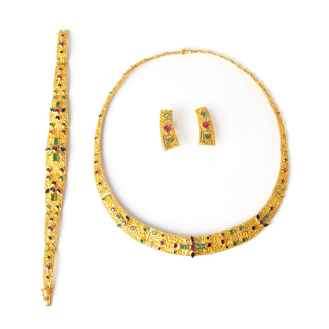 GARNITYR, 18K guld med briljantslipade diamanter, samt fasettslipade smaragder, safirer och rubiner.