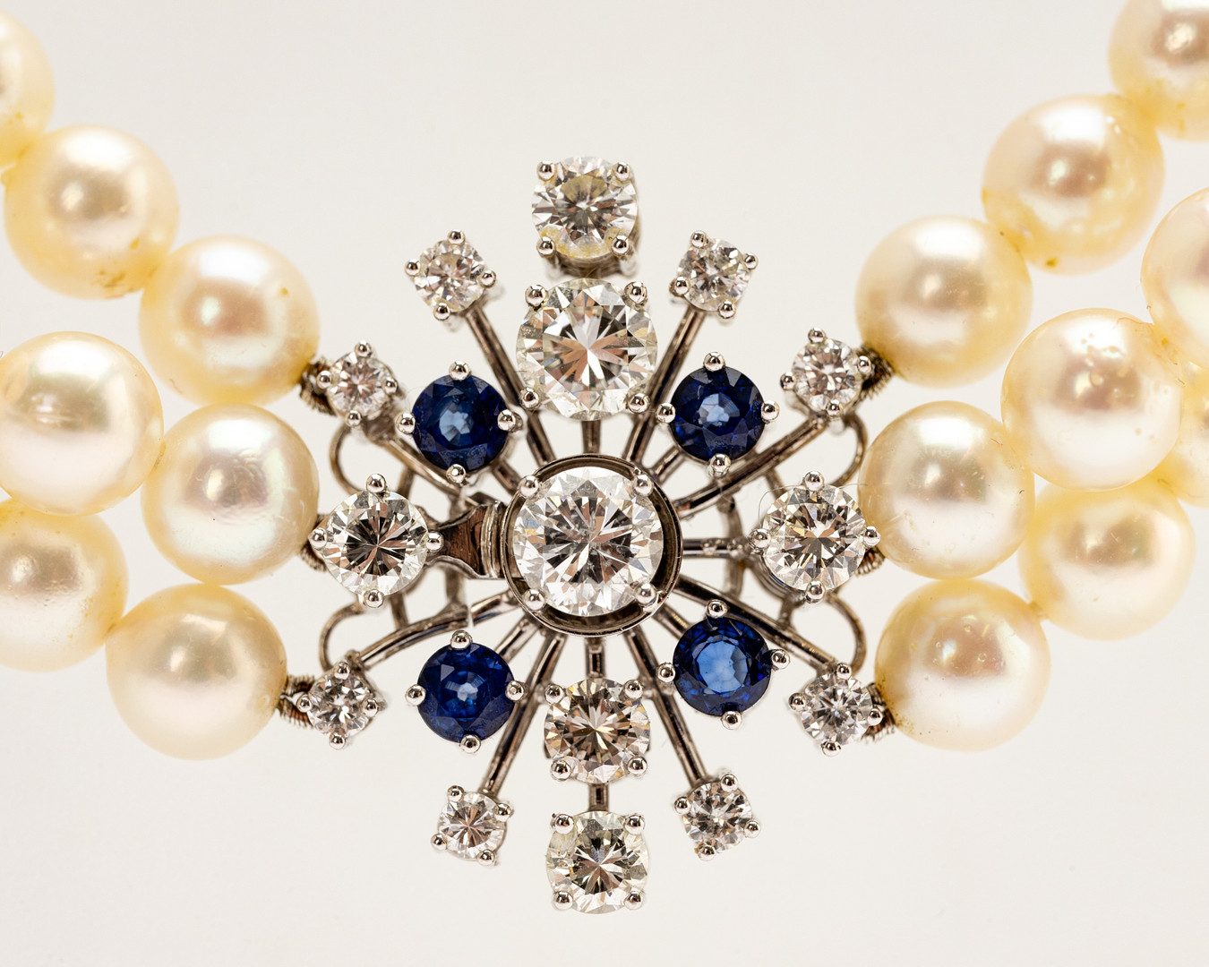 3-reihige Perlenkette mit Weißgoldverschluss, besetzt mit Diamanten und Saphiren.