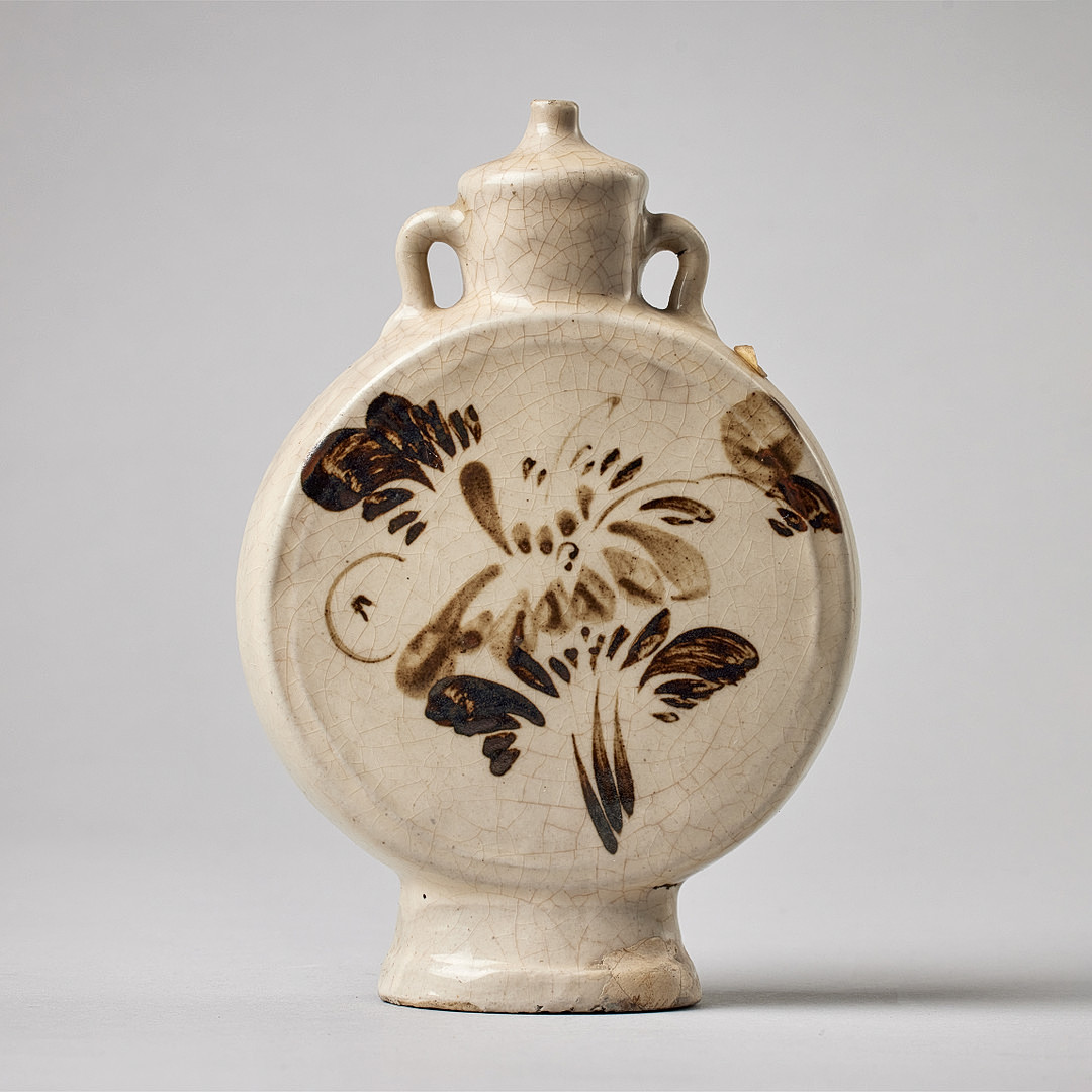 A FLASK-SHAPED CIZHOU WARE WATER DROPPER WITH FLORAL DESIGN.