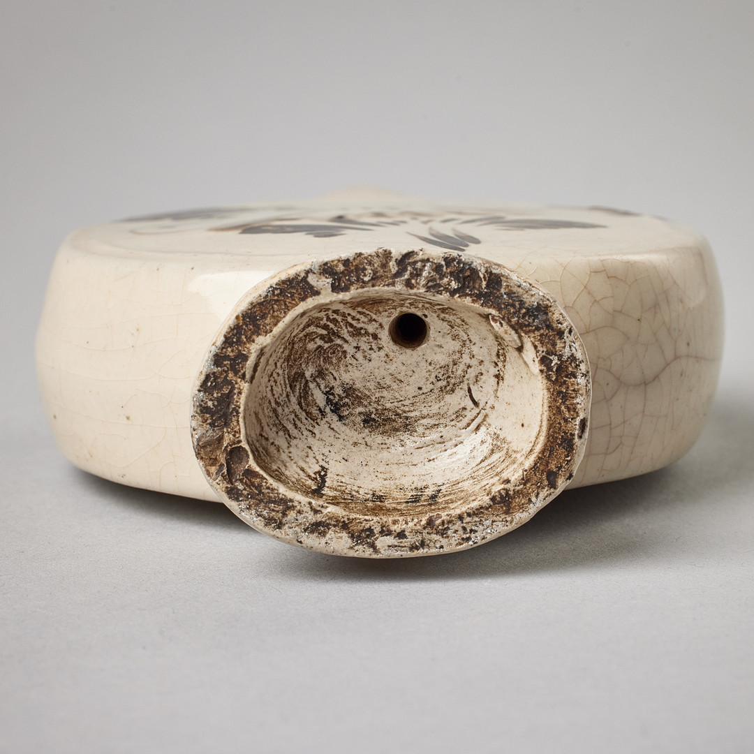 A FLASK-SHAPED CIZHOU WARE WATER DROPPER WITH FLORAL DESIGN.
