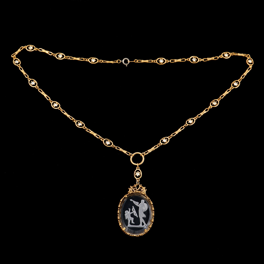 HALSBAND, gulmetall, 1900-tal, fantasilnk, hnge med intaglio av glas med  motiv av Amor och Venus, lnk med dekor av strass. - Stockholms Auktionsverk