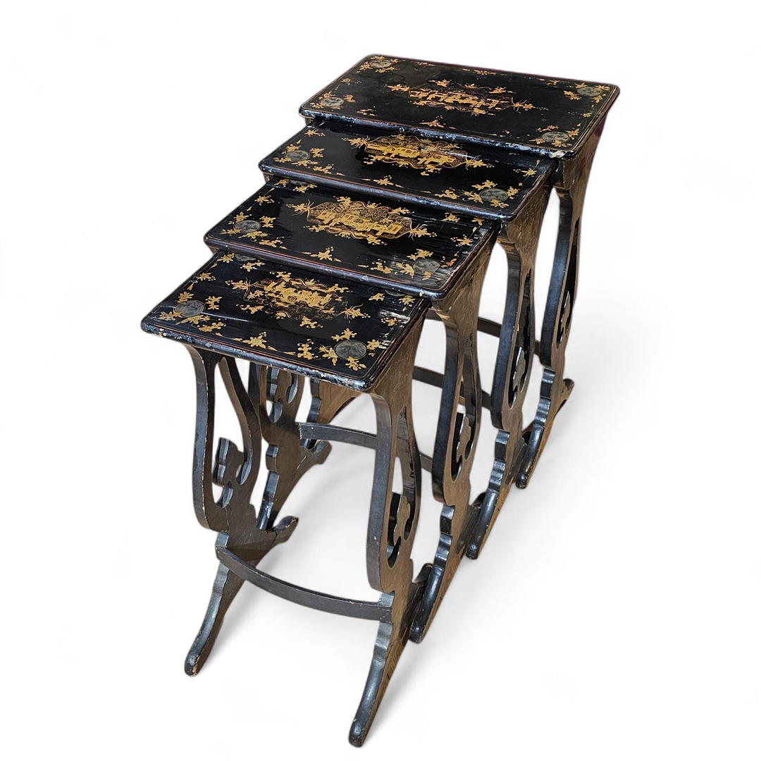 Juego de cuatro mesitas nido circa 1920 en madera lacada y decorada con chinoiseries doradas.