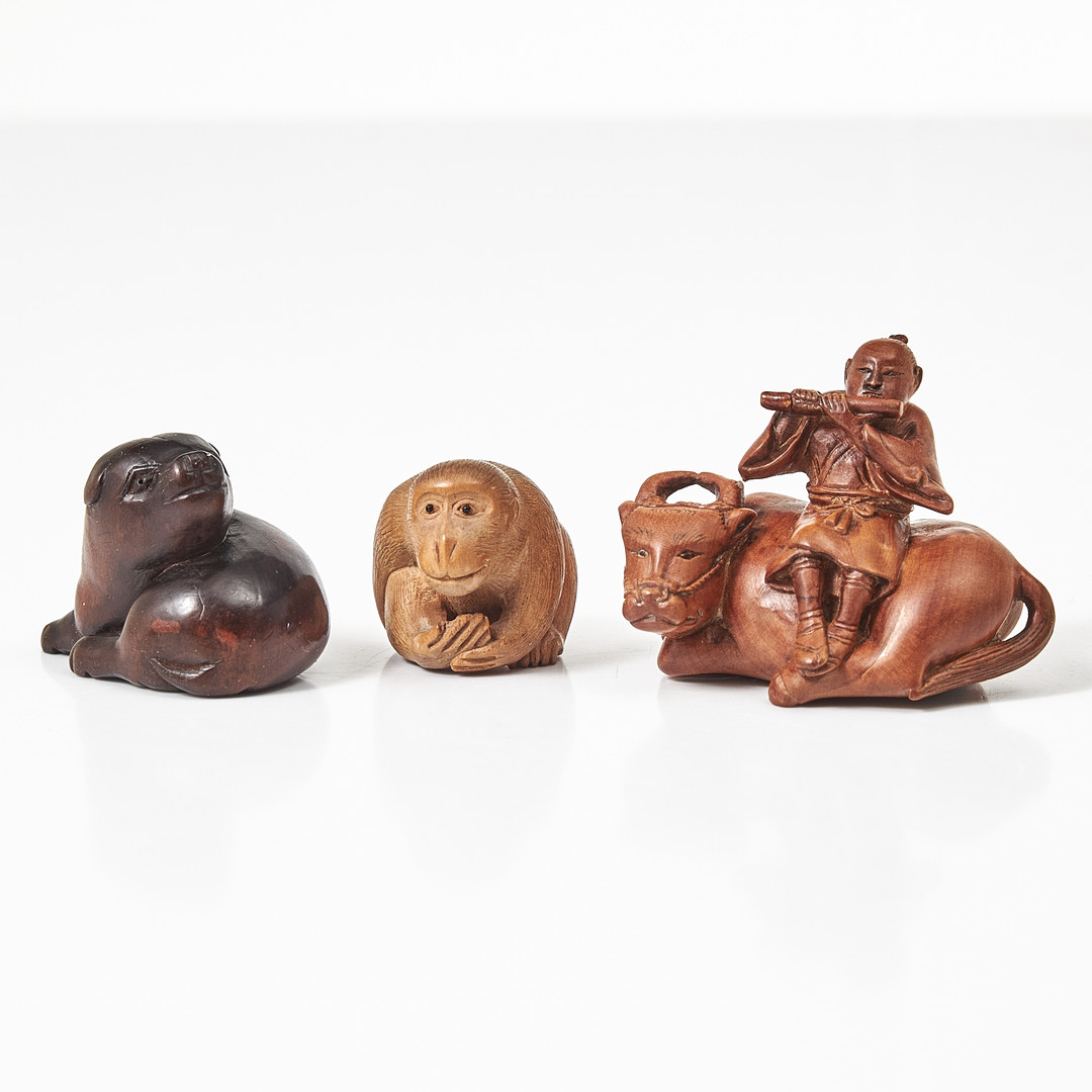 NETSUKE, 3 stycken, Japan, skuret trä, i form av apa, hund samt en flöjtspelande man sittande på buffel.