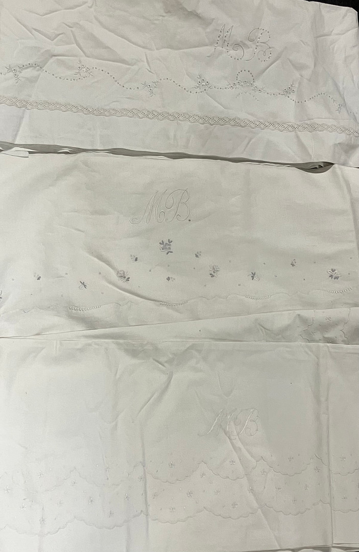 Three white cotton sheets with raised embroidery and lace applications, 20th Century.