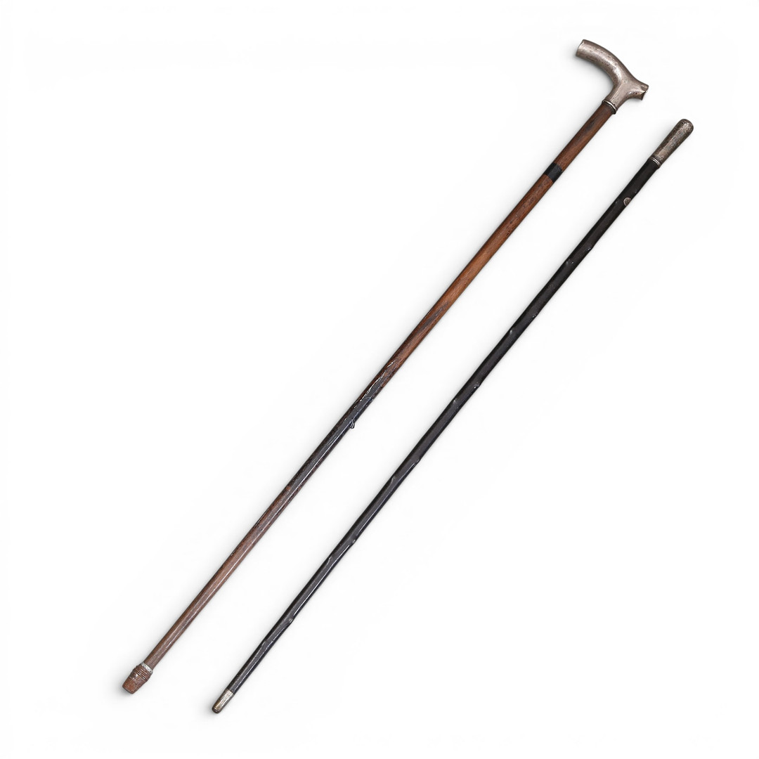 Two walking sticks, probably English, with silver handles and wood shafts, 19th c¡Century.