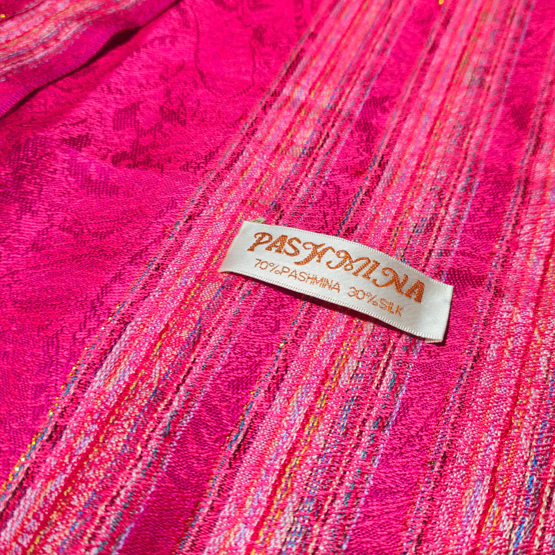 Chal de seda y cachemire color fresa con tiras y discreta tira dorada.