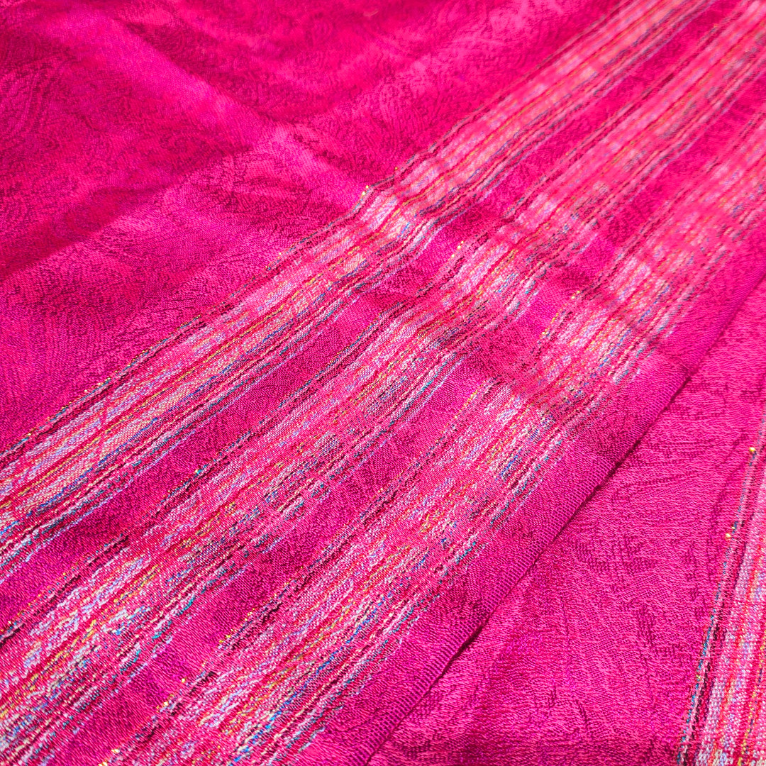 Chal de seda y cachemire color fresa con tiras y discreta tira dorada.