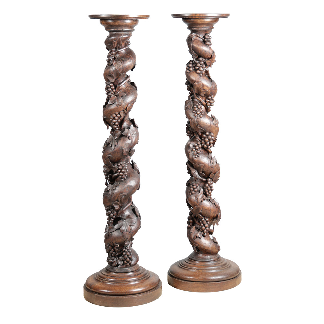 A PAIR OF TALL CARVED GRAPE AND VINE DECORATED COLUMNS (2).