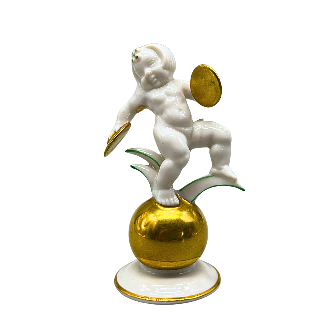 PORZELLANFIGUR PUTTO MIT ZIMBELN, HUTSCHENREUTHER.