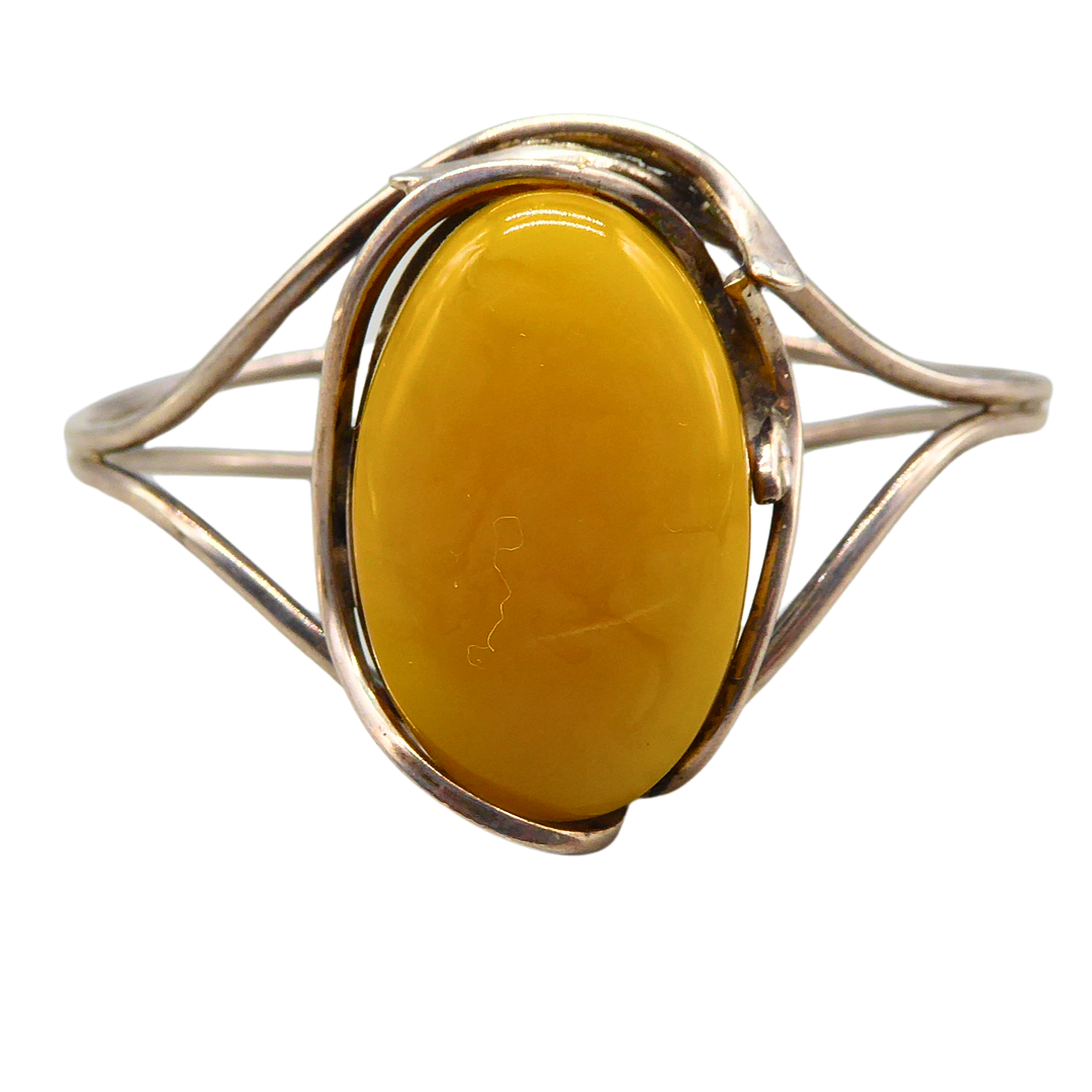 VINTAGE-ARMREIF IST AUS STERLINGSILBER GEFERTIGT UND MIT EINEM GROSSEN, OVALEN BUTTERSCOTCH-BERNSTEIN IM CABOCHON-SCHLIFF BESETZT.