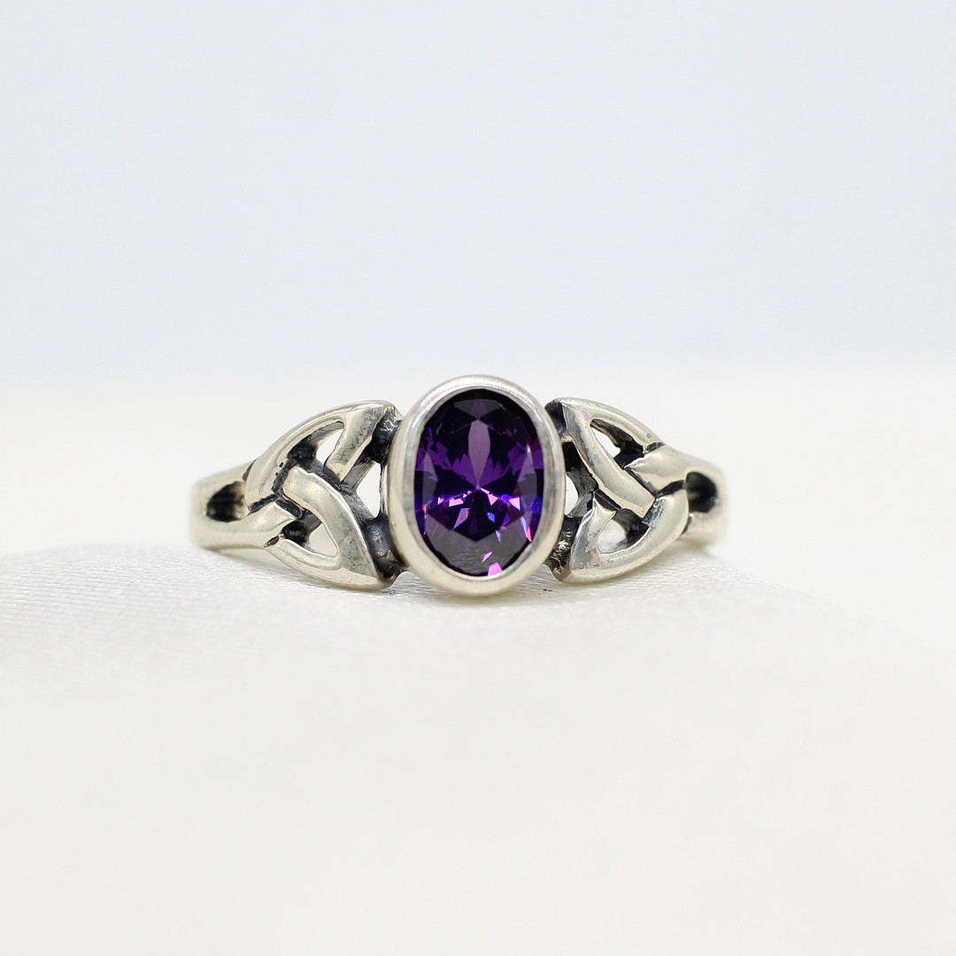 SILVER CELTIC RING WITH PURPLE CUBIC ZIRCONIA.