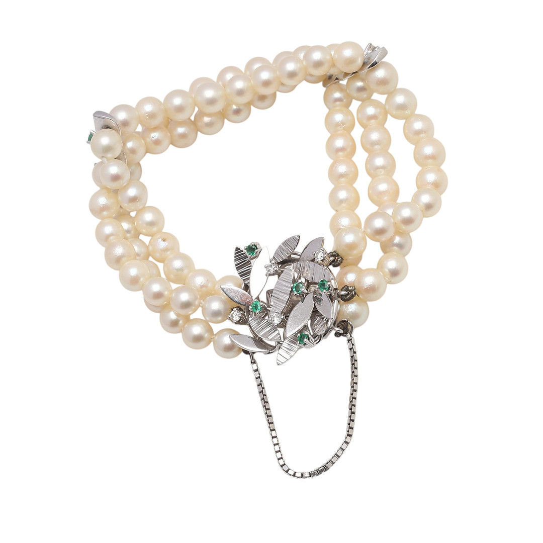 Three-strand pearls bracelet with a gold and gemstones clasp.