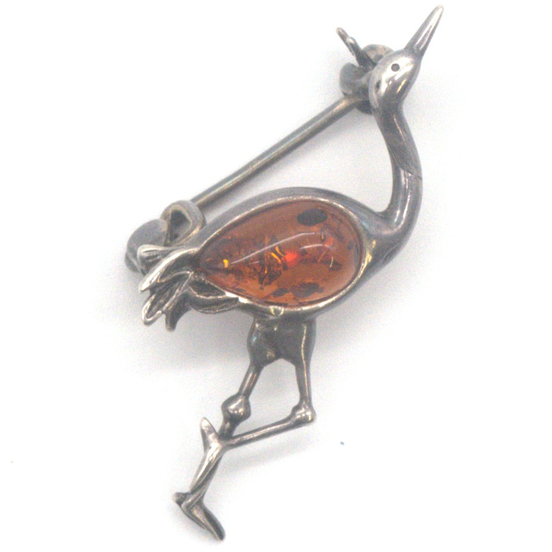 DESIGNER BROSCHE SILBER GEPRÜFT IN PLASTISCHER FORM EINES VOGELS, MIT HONIGBERNSTEIN-CABOCHON BESETZT, DEUTSCHLAND, 20. JAHRHUNDERT, PUNZIERT.