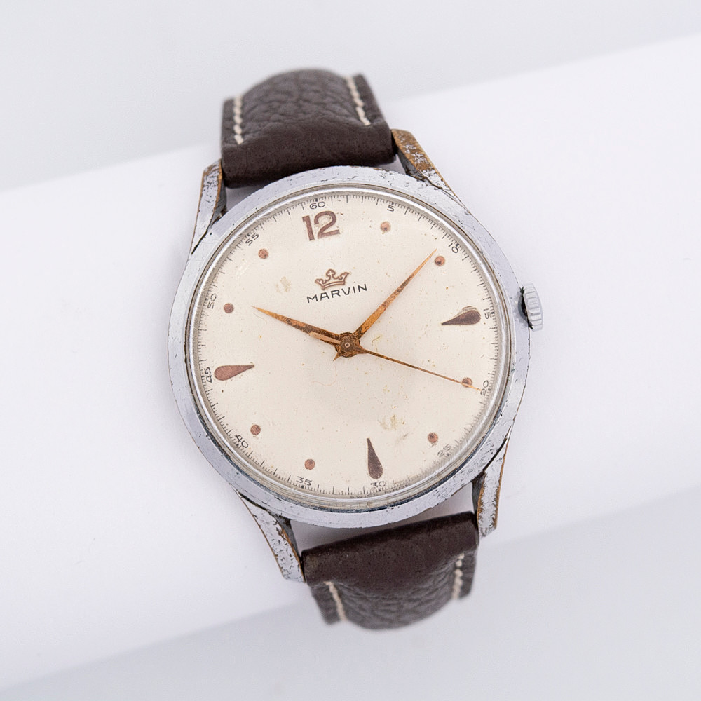 MARVIN ARMBANDUHR MIT MARVIN-UHRWERK, KALIBER 560 MIT 17 STEINEN, HANDAUFZUG, GEHÄUSE VERCHROMT, GEHÄUSEBODEN EDELSTAHL, 1950ER JAHRE, BRAUNES LEDERARMBAND.