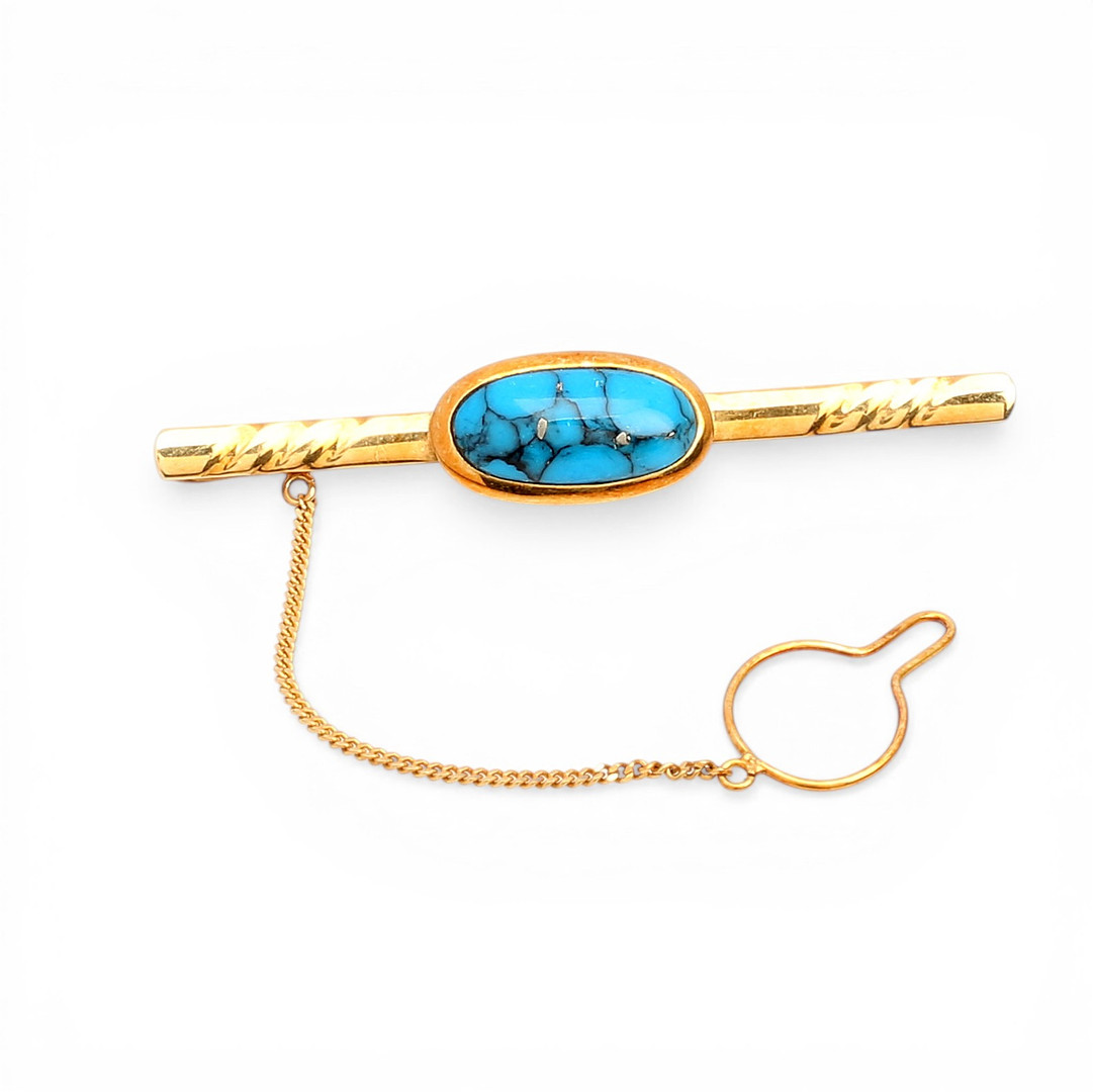Tie pin in gold and gemstones.