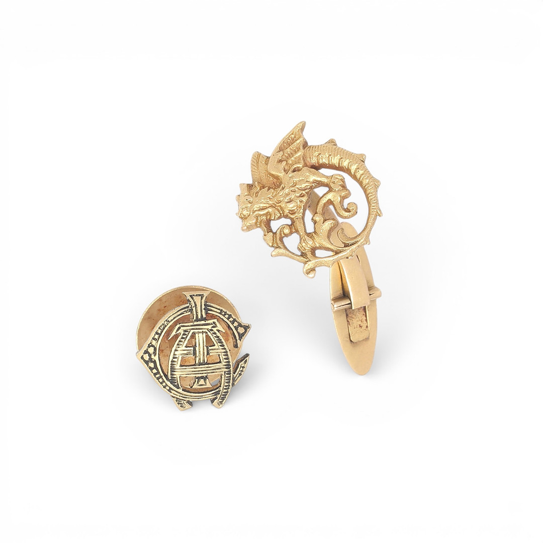 A Modernist dragon-shaped cufflink and a gold button, early 20th Century.